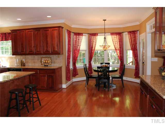 5101 Bartons Enclave Lane Raleigh, NC 27613 - Photo 10 of 25 a kitchen with stainless steel appliances granite countertop a stove top oven a sink with dining table and chairs
