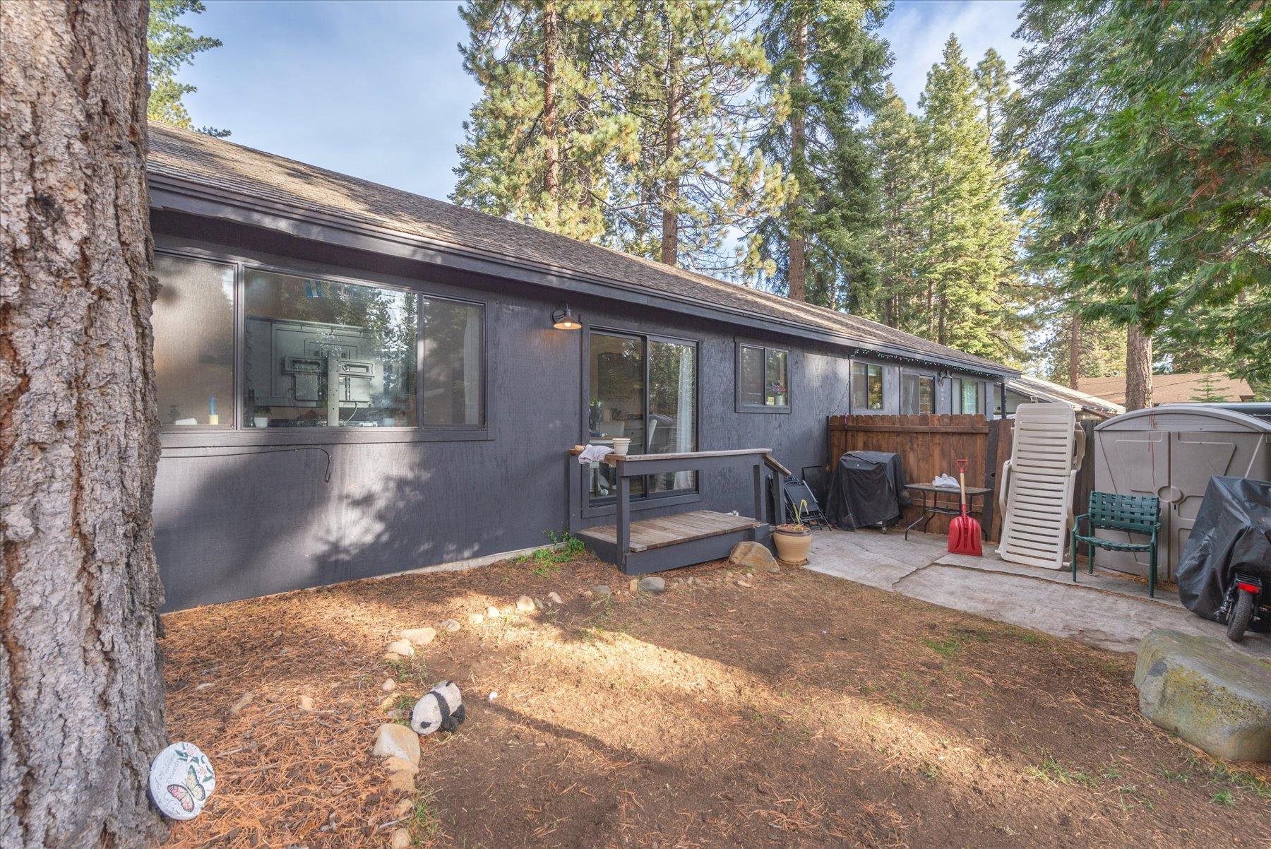 6917 Toyon Road Tahoe Vista, CA 96148 - Photo 22 of 25 a view of a patio with table and chairs a barbeque and a large tree