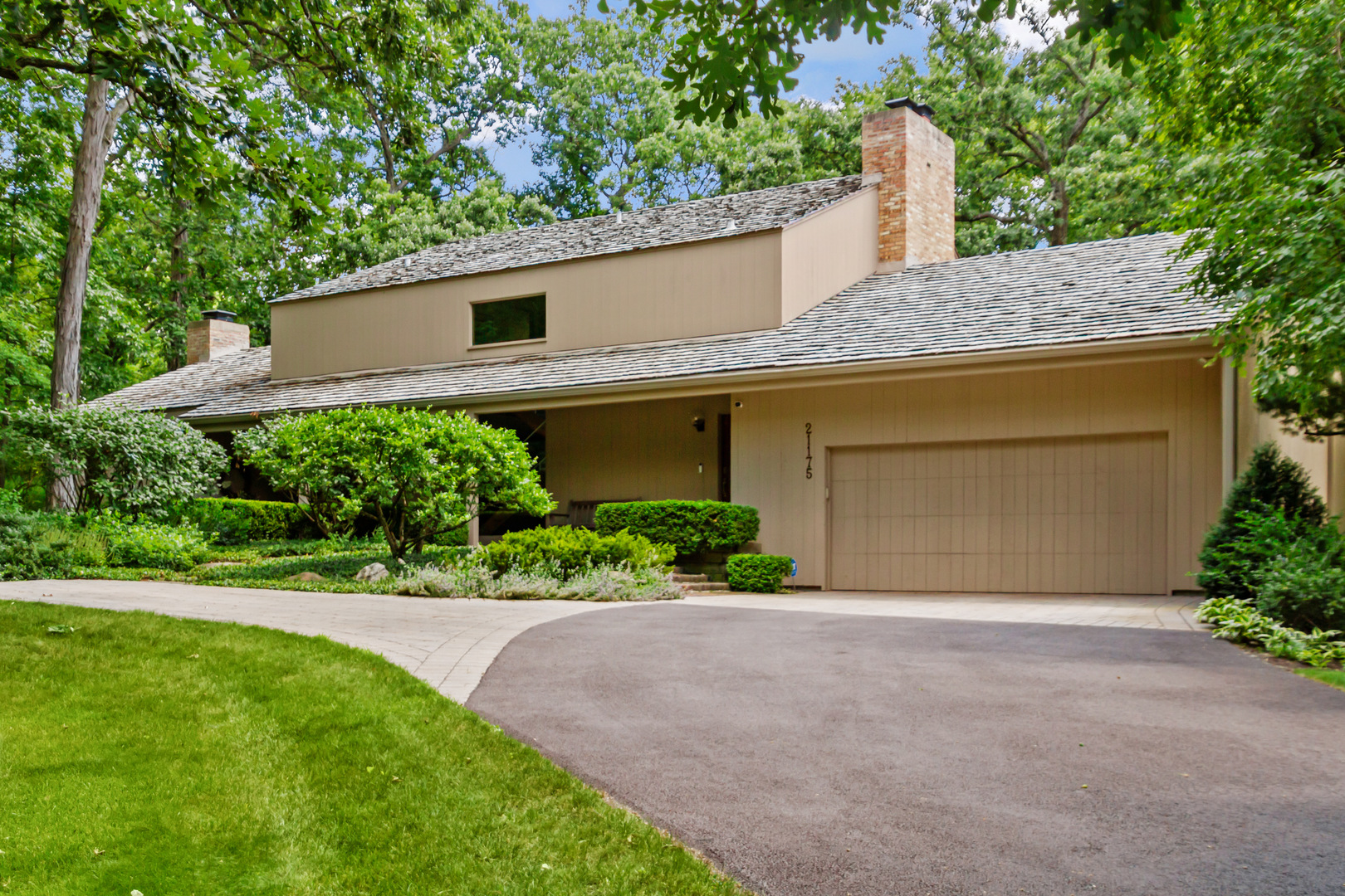 a front view of a house with a garden