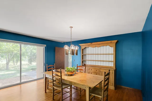 a kitchen with stainless steel appliances a stove a sink a microwave a dining table and chairs