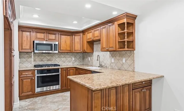 a kitchen with granite countertop a stove and a microwave