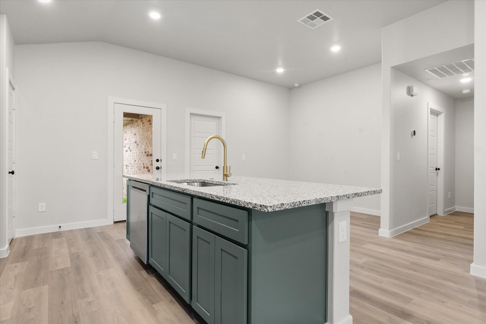 8605 29th Street Lubbock, TX 79407 - Photo 11 of 21 a kitchen with a sink a counter space and wooden floor