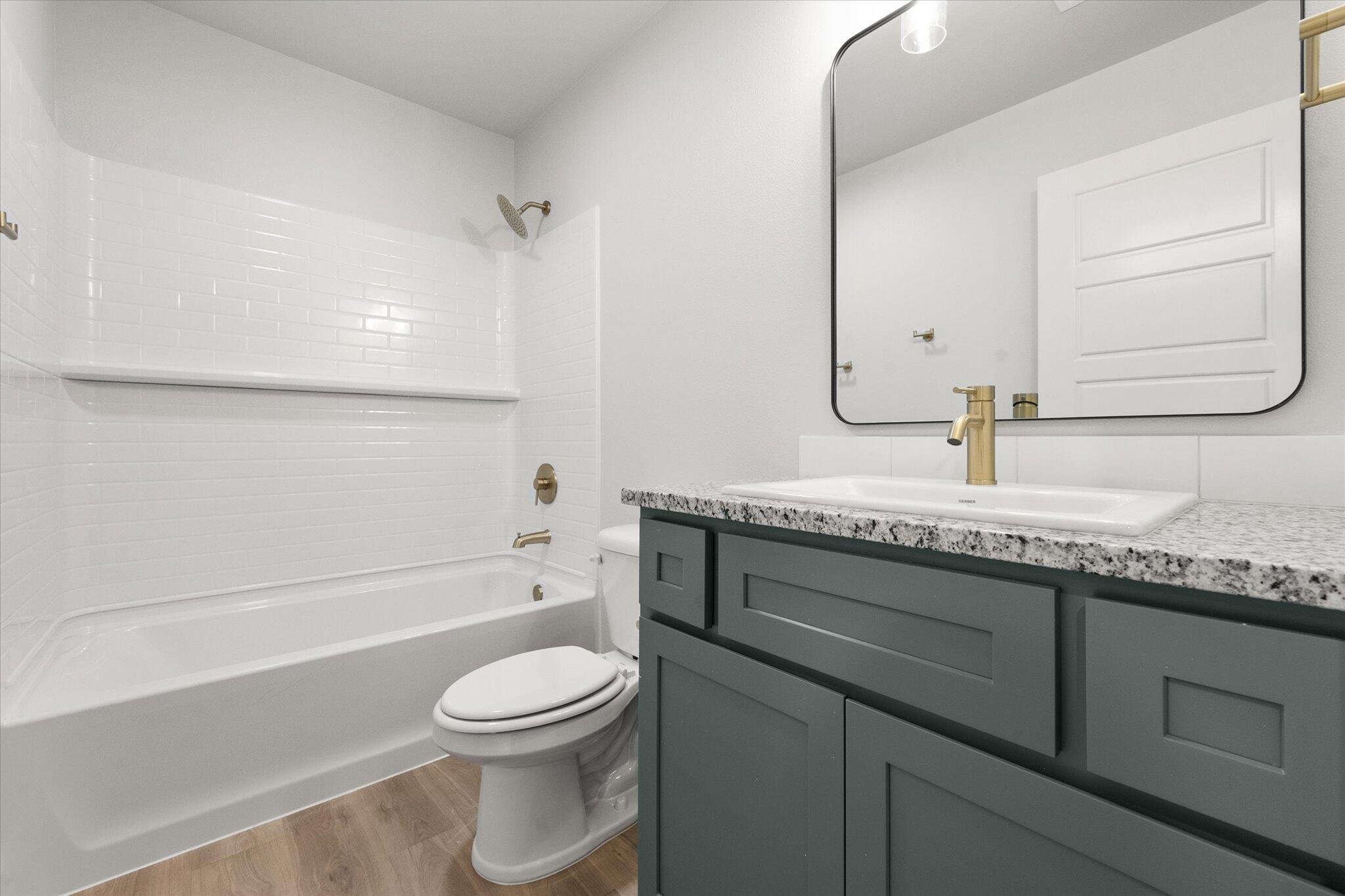 8605 29th Street Lubbock, TX 79407 - Photo 18 of 21 a bathroom with a granite countertop toilet sink and mirror