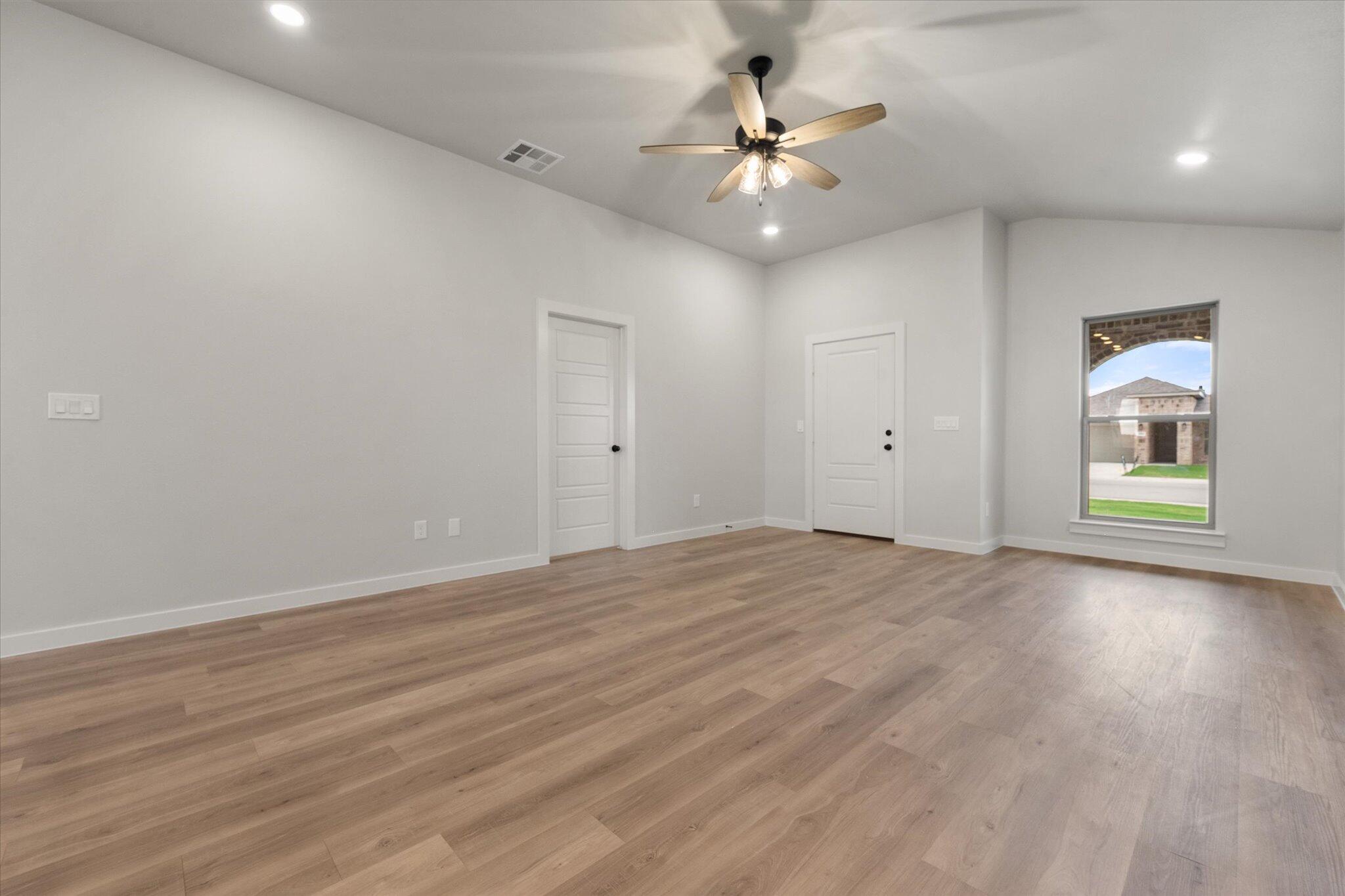 8605 29th Street Lubbock, TX 79407 - Photo 5 of 21 an empty room with wooden floor and windows