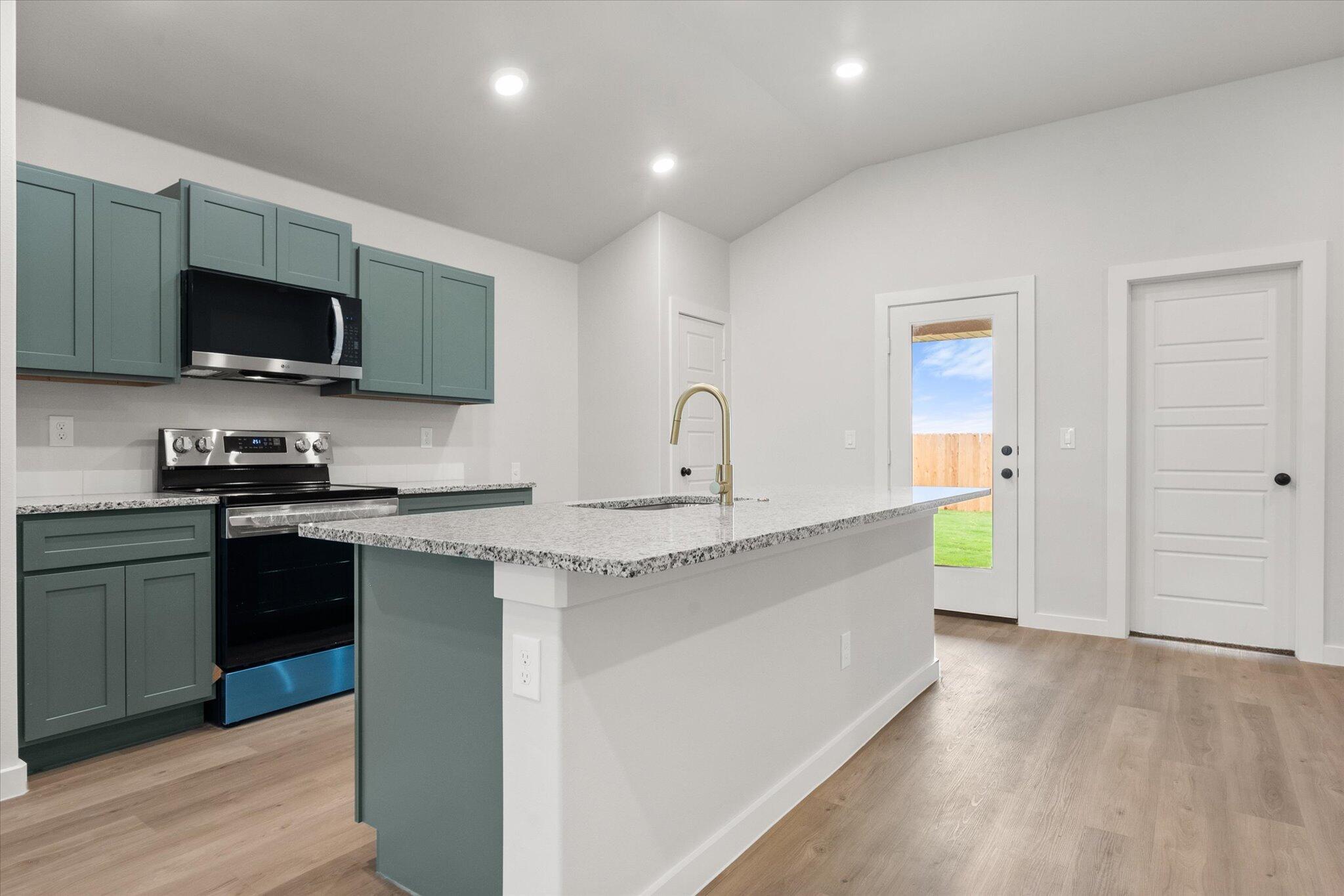 8605 29th Street Lubbock, TX 79407 - Photo 7 of 21 a kitchen with stainless steel appliances granite countertop a sink and a stove top oven