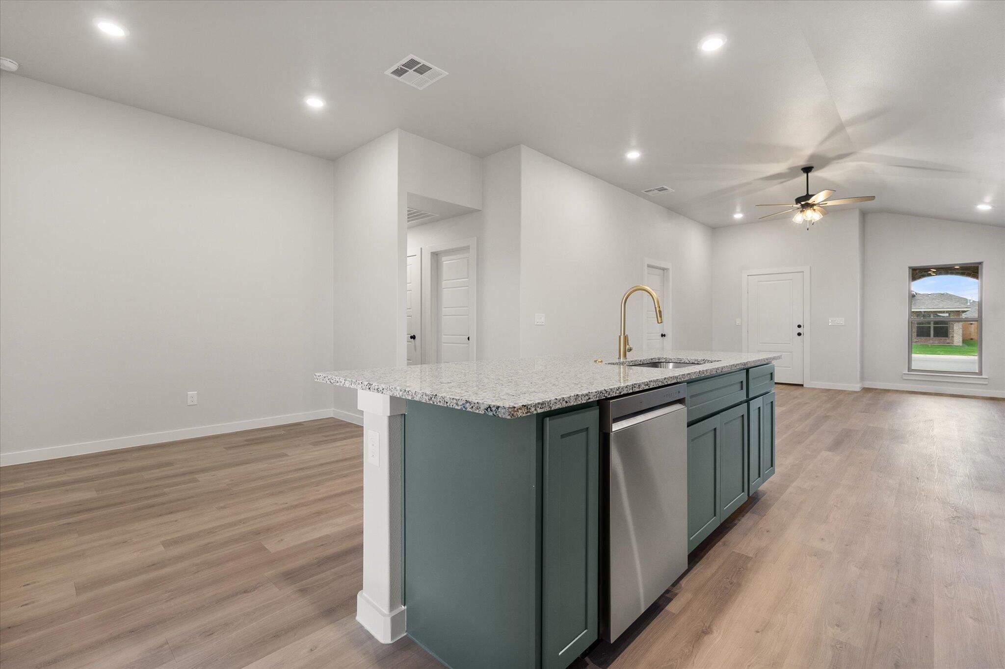 8605 29th Street Lubbock, TX 79407 - Photo 10 of 21 a kitchen with granite countertop a sink cabinets and wooden floor