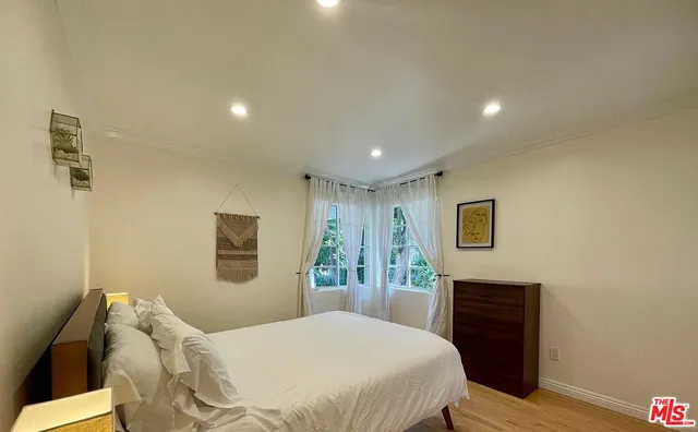 a bedroom with a bed and a potted plant