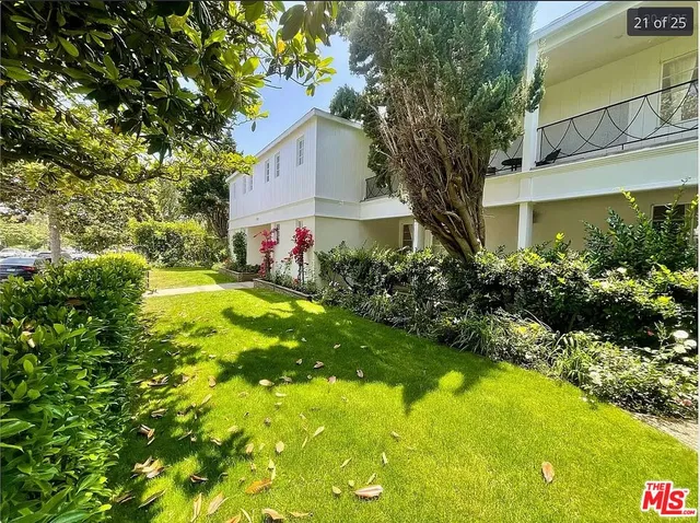 a view of a house with a big yard and large tree