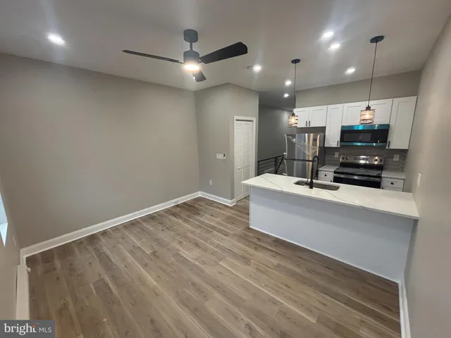 a view of kitchen with sink microwave and refrigerator