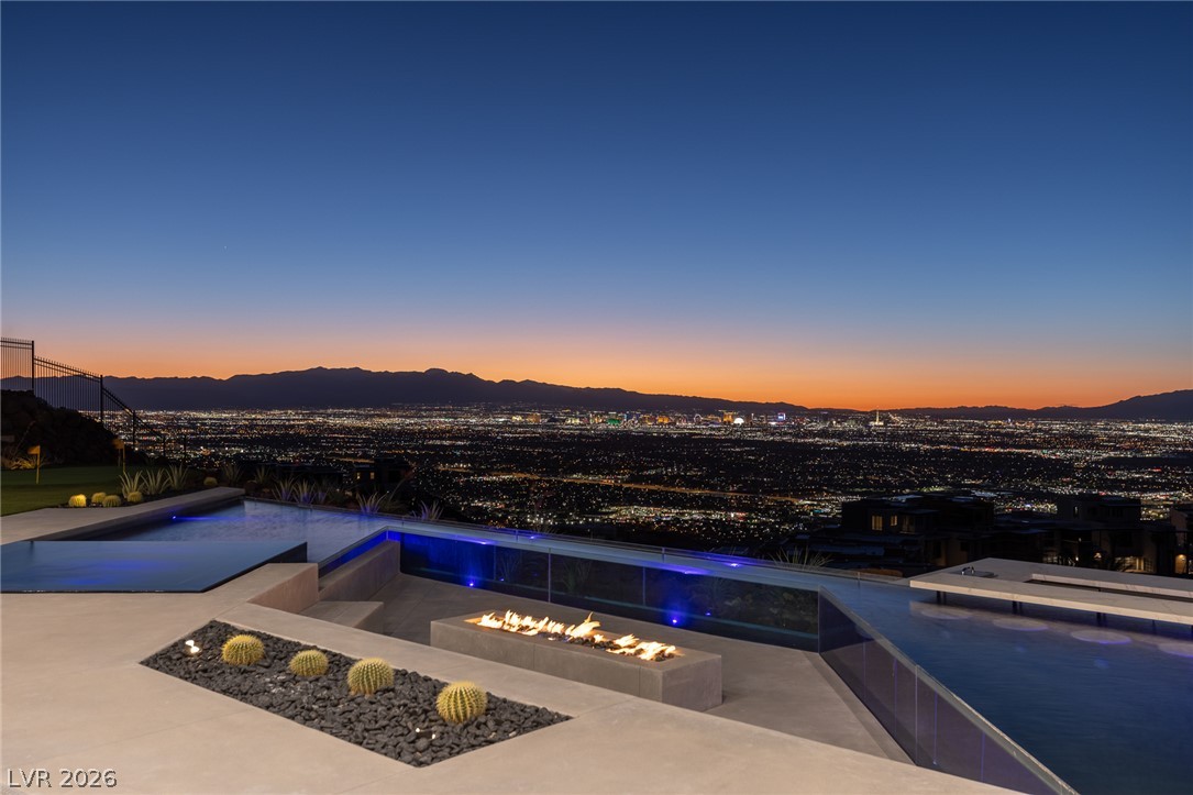 563 Grand Rim Drive Henderson, NV 89012 - Photo 50 of 70 Witness the city lights sparkle from this elevated oasis featuring a tranquil pool and an inviting fire pit.