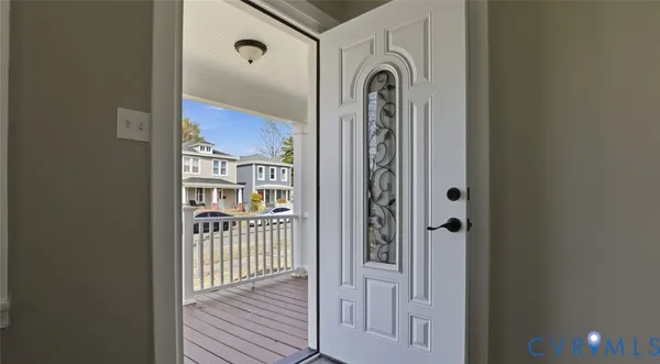 a view of a hallway with wooden floor and a bathroom