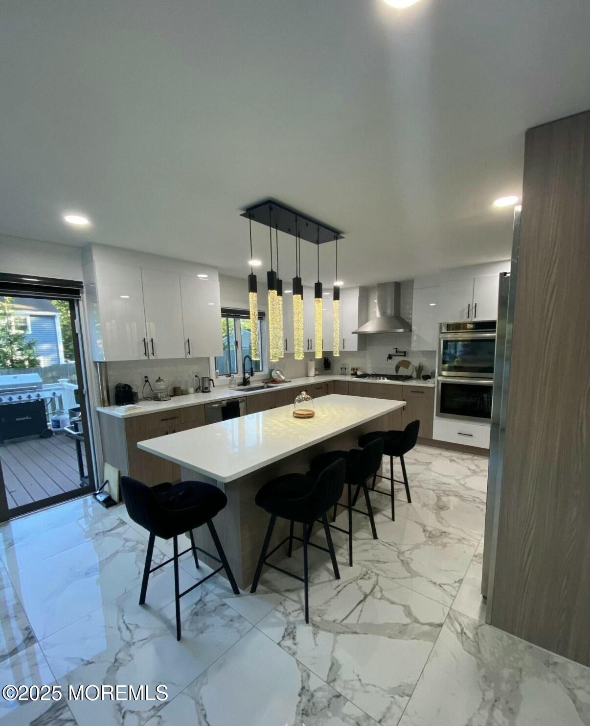 604 Van Note Parkway Oakhurst, NJ 07755 - Photo 3 of 19 a kitchen with stainless steel appliances kitchen island a table and chairs in it