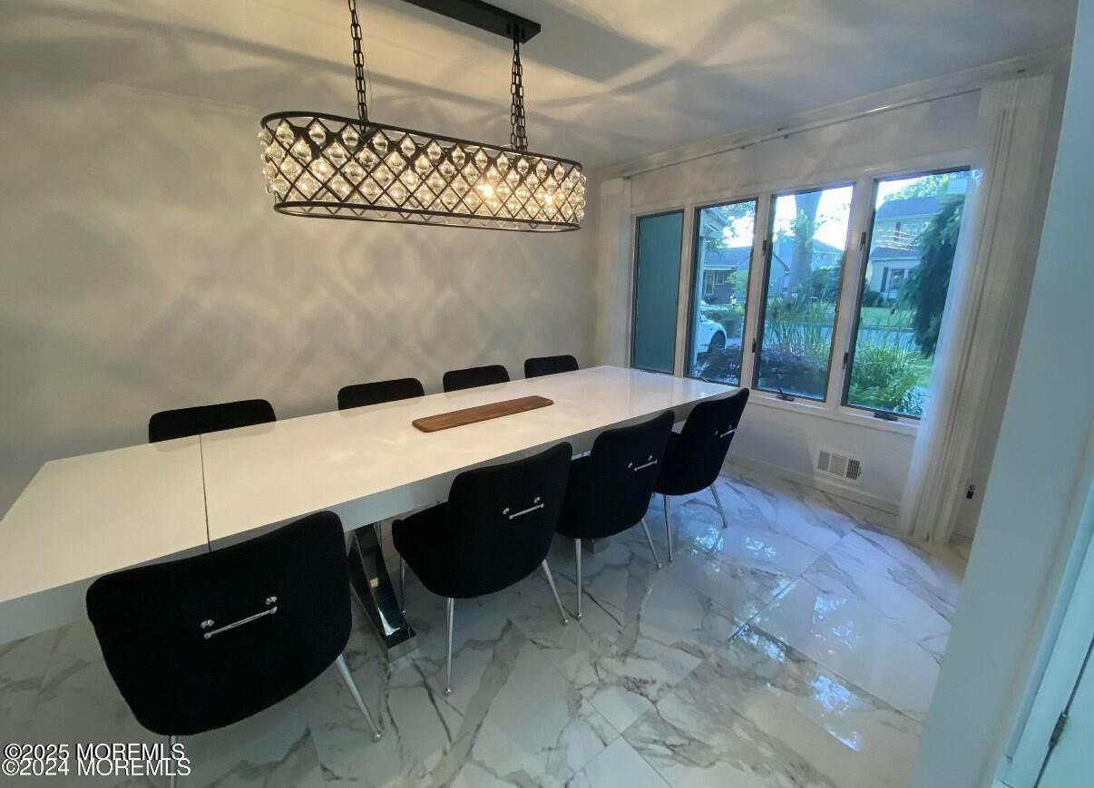 604 Van Note Parkway Oakhurst, NJ 07755 - Photo 7 of 19 a kitchen with a table chairs and a wooden door