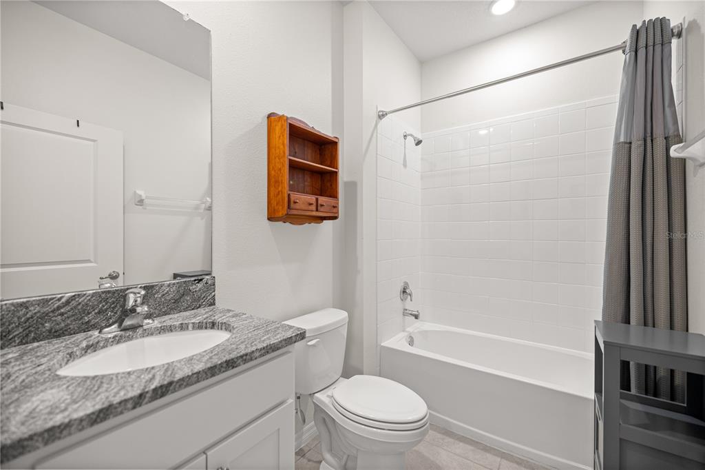 6125 Southwest 88th Loop Ocala, FL 34476 - Photo 18 of 29 a bathroom with a granite countertop sink toilet and shower