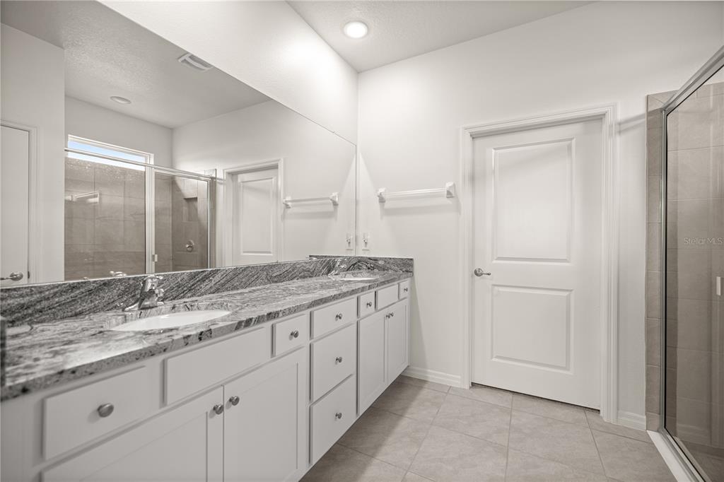 6125 Southwest 88th Loop Ocala, FL 34476 - Photo 21 of 29 a bathroom with a granite countertop sink and a mirror