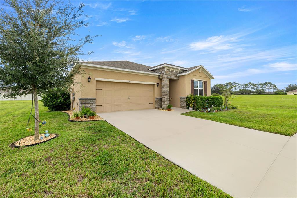 6125 Southwest 88th Loop Ocala, FL 34476 - Photo 3 of 29 a front view of a house with a yard and garage