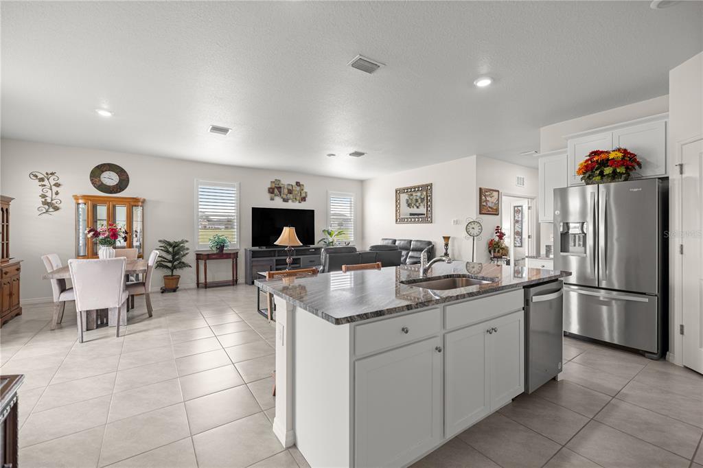 6125 Southwest 88th Loop Ocala, FL 34476 - Photo 10 of 29 a kitchen with stainless steel appliances granite countertop a sink and a refrigerator