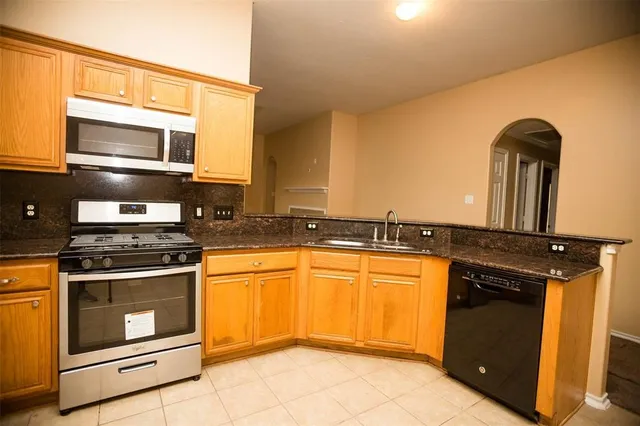 a kitchen with a sink stove and cabinets