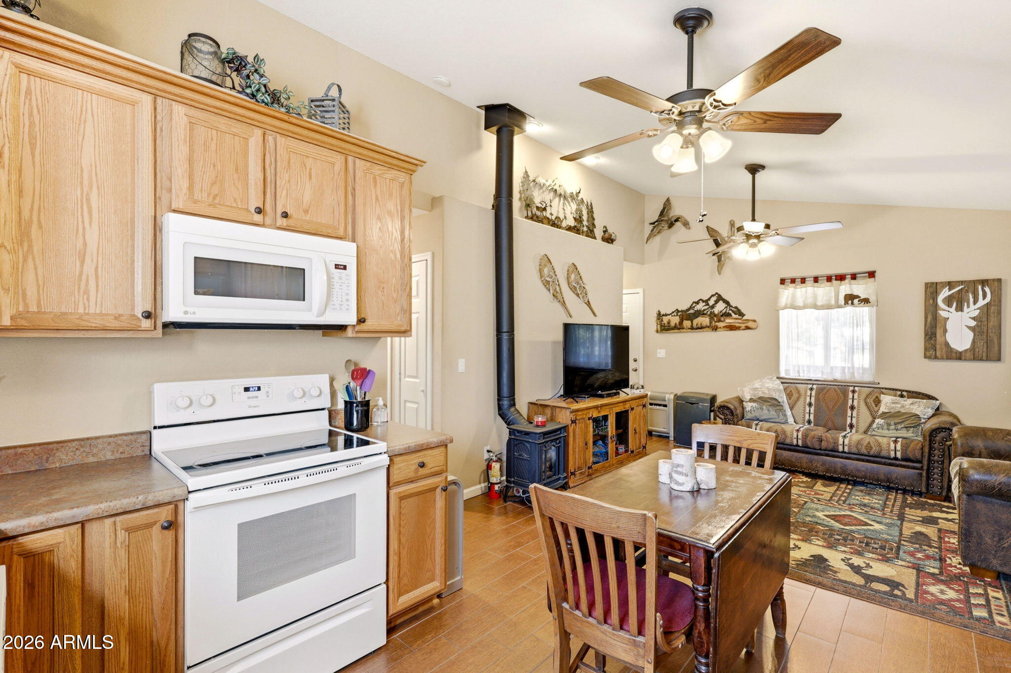 2112 Fishermans Road Overgaard, AZ 85933 - Photo 6 of 18 a kitchen with stainless steel appliances granite countertop a stove a sink dishwasher a dining table and chairs with wooden floor
