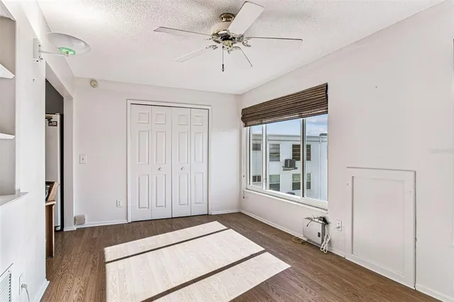 a bedroom with a bed and a chandelier fan
