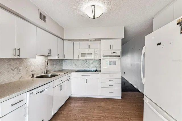 a bathroom with a granite countertop bathtub shower sink vanity mirror and toilet