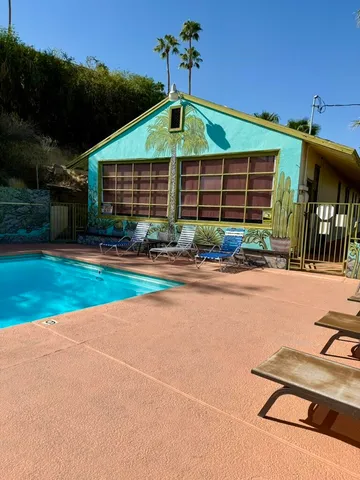 a view of a backyard with couches plants and large trees