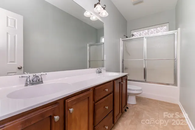 a bathroom with a granite countertop sink a toilet and a mirror