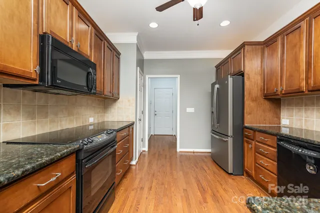 a kitchen with granite countertop wooden cabinets stainless steel appliances and a sink