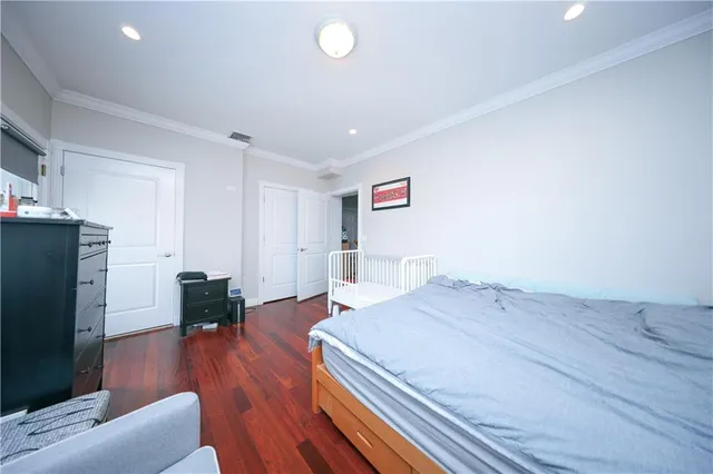 a spacious bedroom with a bed and a flat screen tv