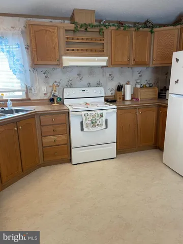 a kitchen with cabinets and white appliances