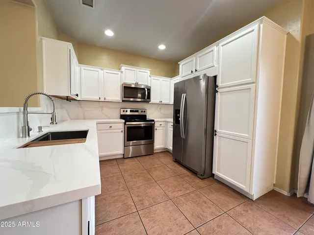 a kitchen with stainless steel appliances granite countertop a refrigerator sink and microwave