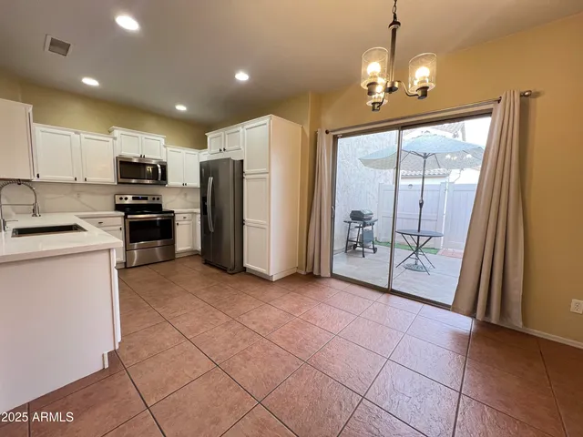 a view of a kitchen with fridge and wooden floor