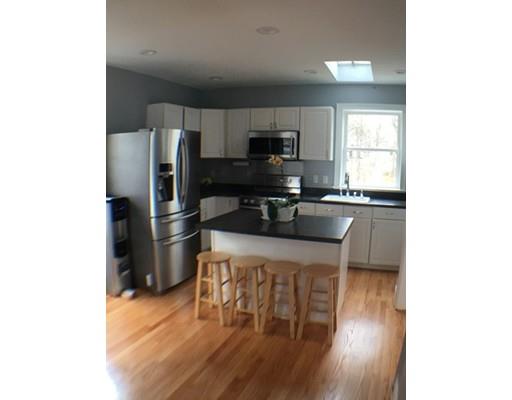 12 Johnston Terrace Saugus, MA 01906 - Photo 7 of 24 a kitchen with stainless steel appliances a microwave a stove a refrigerator a sink a dining table and chairs