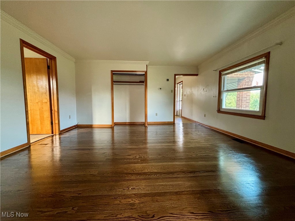 164 Locust Lane Follansbee, WV 26037 - Photo 4 of 19 Unfurnished bedroom with crown molding, dark wood-style flooring, and a closet
