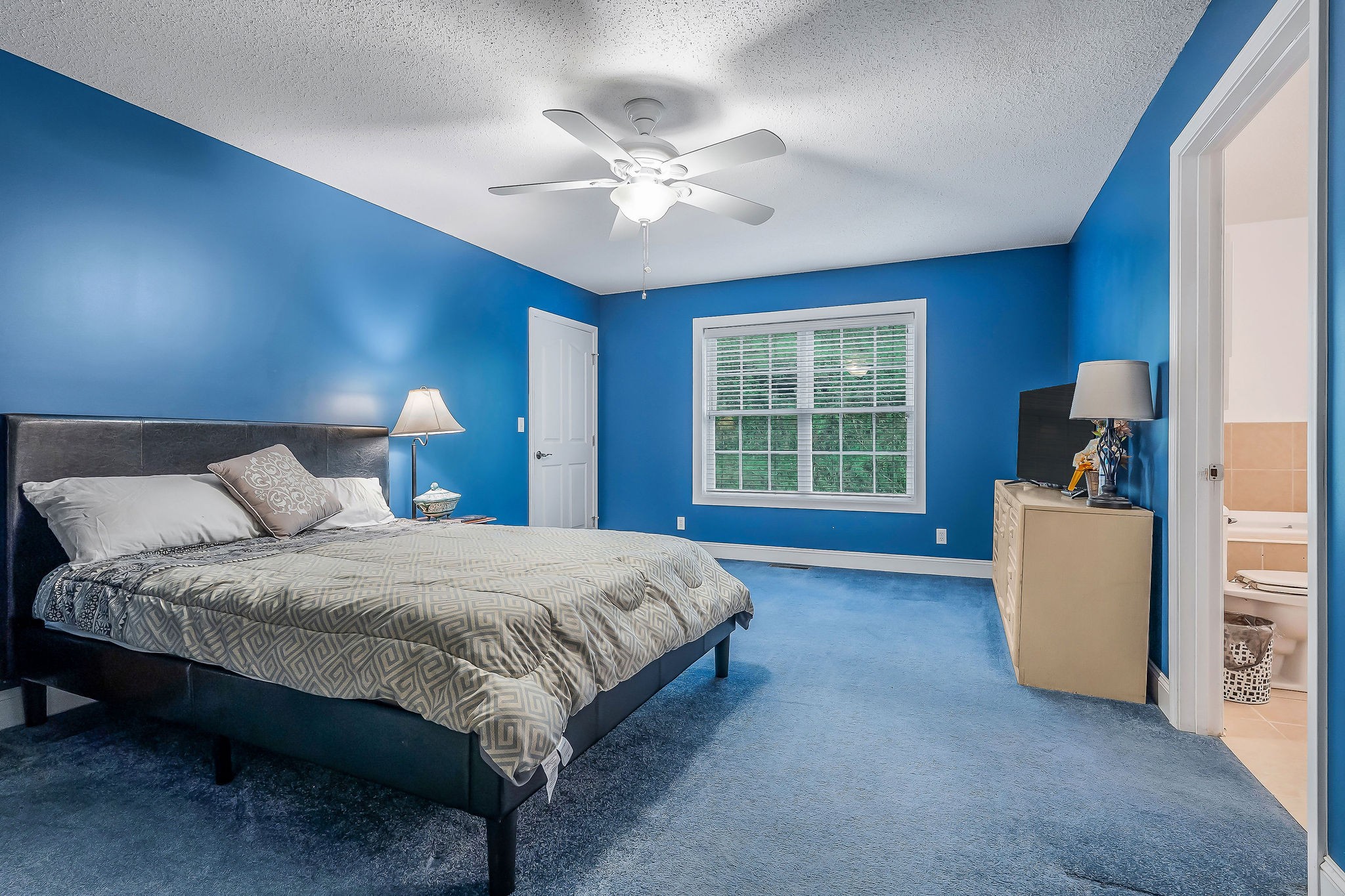 341 Pumpkin Hollow Road Liberty, TN 37095 - Photo 20 of 52 a spacious bedroom with a bed and a chandelier