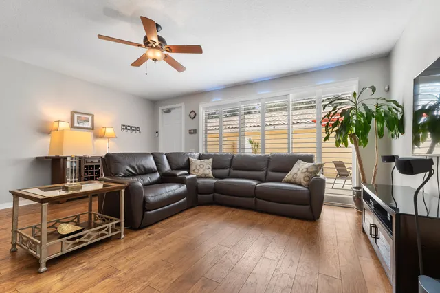 a living room with furniture and a ceiling fan