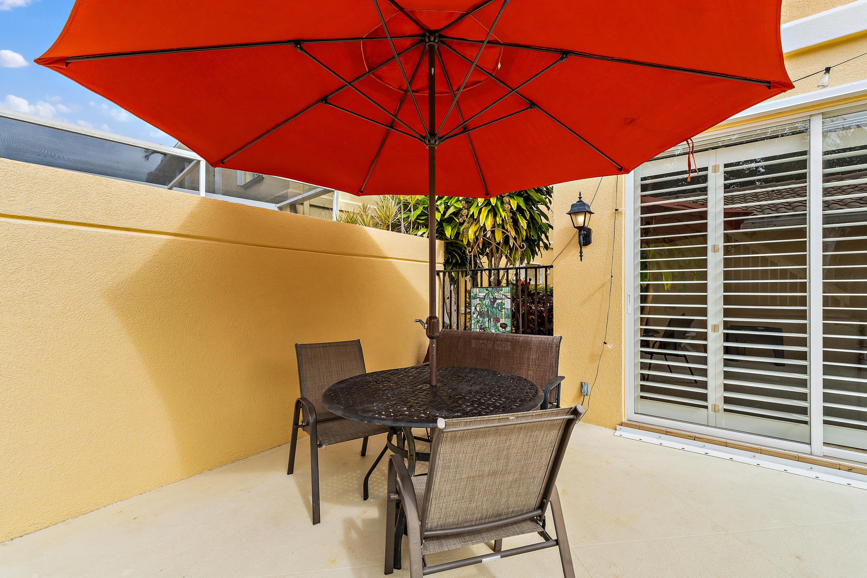 4050 Parkside Drive Jupiter, FL 33458 - Photo 44 of 59 a backyard of a house with table and chairs under an umbrella