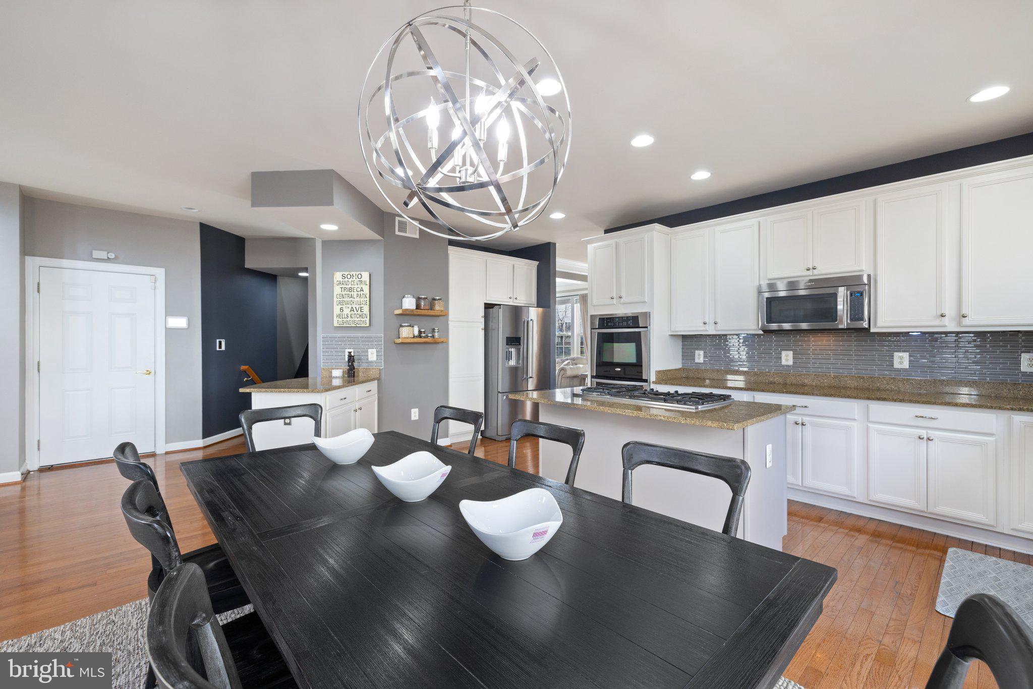 42624 Emperor Ashburn, VA 20148 - Photo 16 of 56 a kitchen with stainless steel appliances granite countertop a stove top oven a dining table and chairs with wooden floor