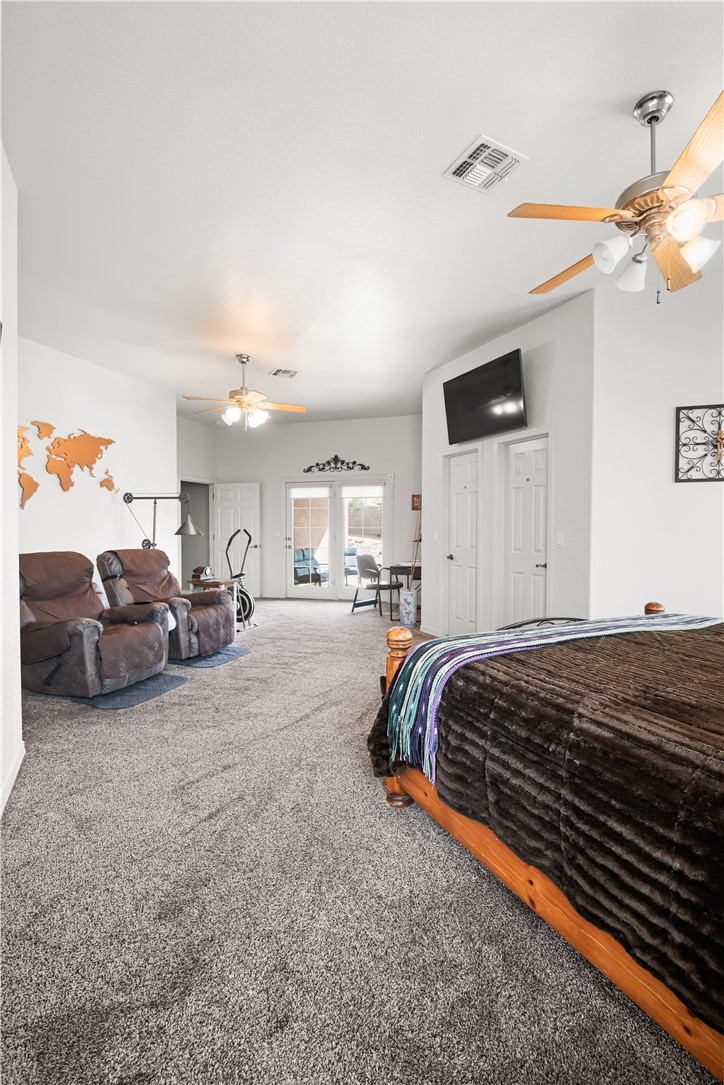 2898 Mountain Trail Road Kingman, AZ 86401 - Photo 64 of 75 a spacious bedroom with a bed a couch and a ceiling fan