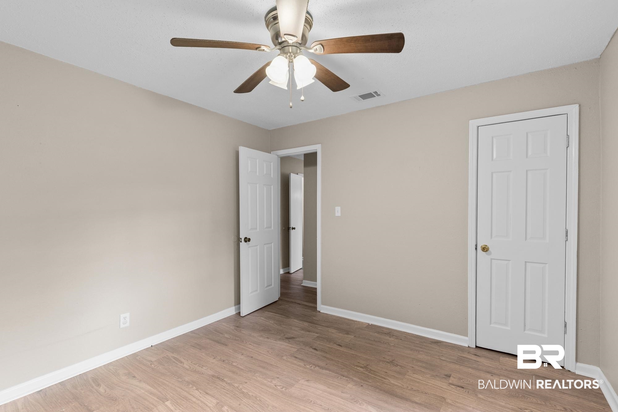 1560 Military Road Mount Vernon, AL 36560 - Photo 21 of 26 Neutral-toned walls complement the wood-finish flooring