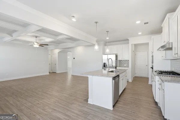 a kitchen with stainless steel appliances a stove top oven a sink dishwasher and a refrigerator