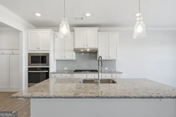 a kitchen with kitchen island granite countertop a counter space appliances and cabinets