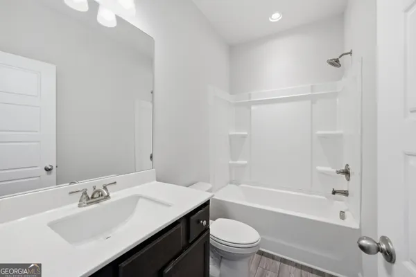 a bathroom with a sink toilet vanity and bathtub
