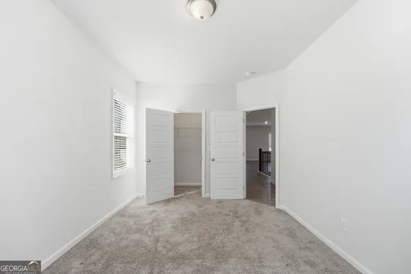 an empty room with windows and closet