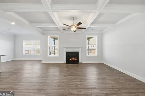 an empty room with windows a fireplace