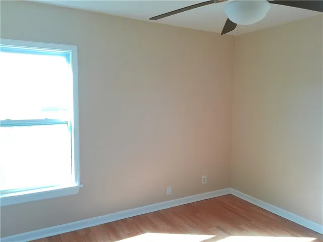 a view of a small space with wooden floor and a window