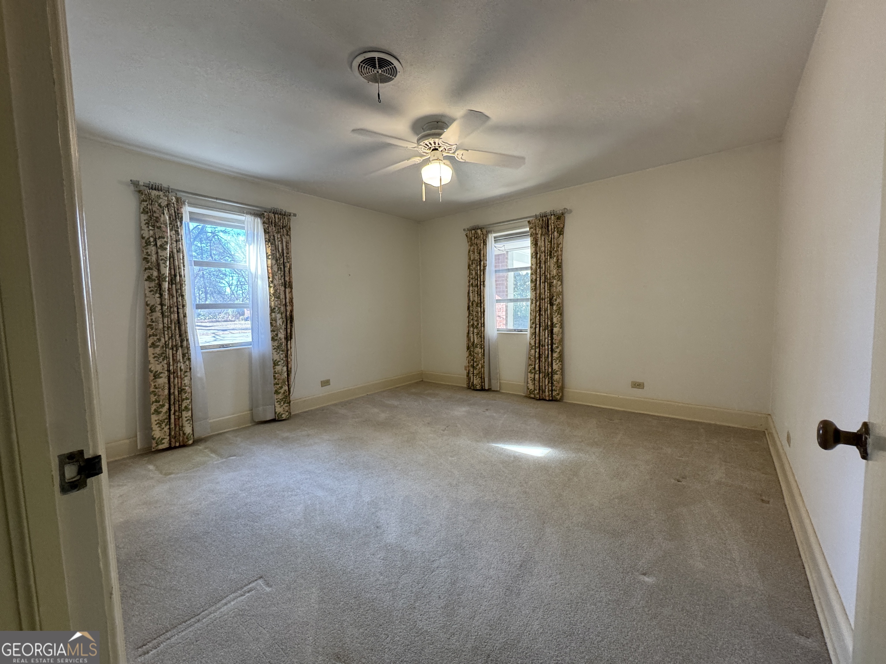 465 Cedar Street Metter, GA 30439 - Photo 17 of 47 an empty room with chandelier fan and windows