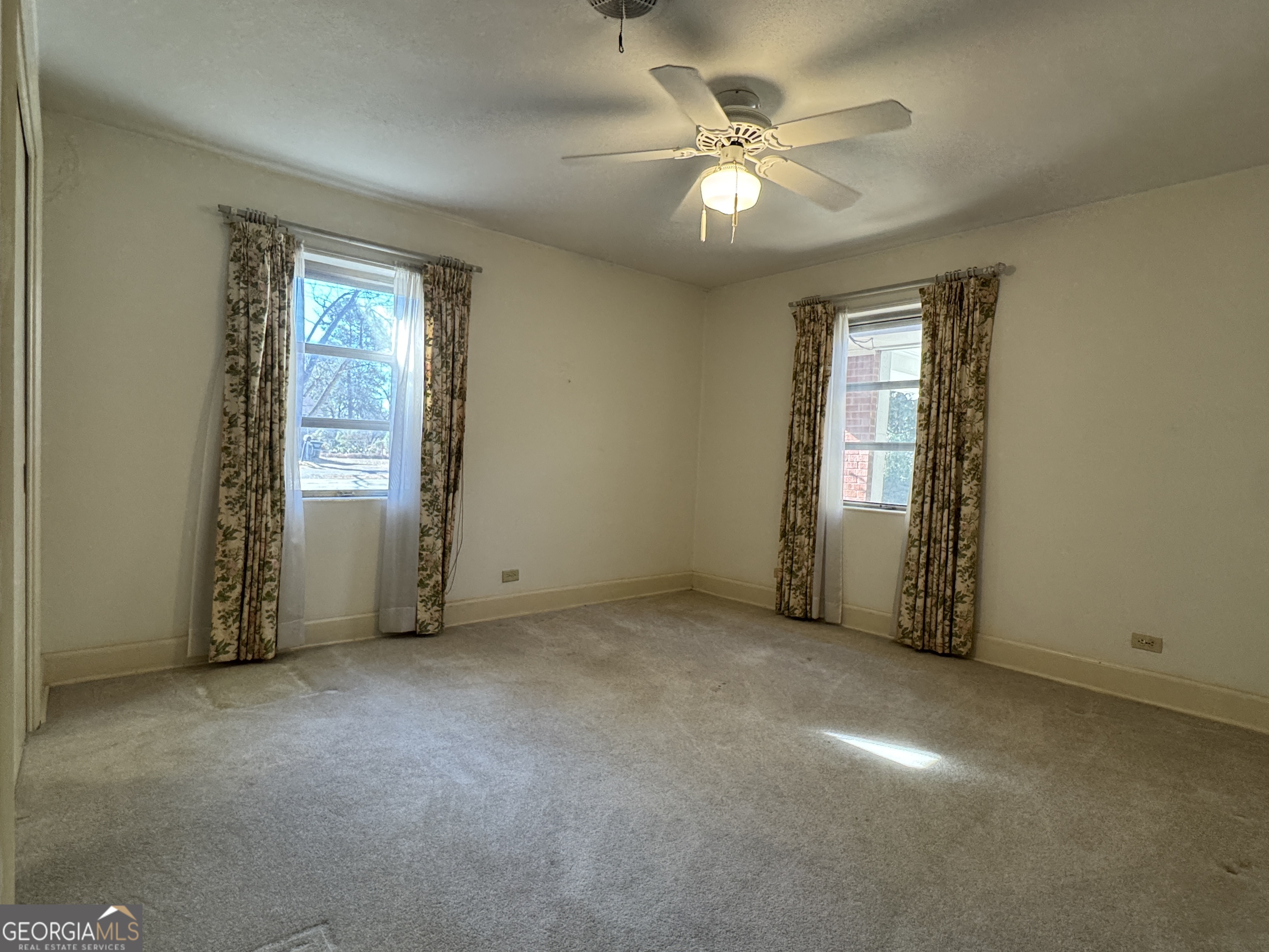 465 Cedar Street Metter, GA 30439 - Photo 25 of 47 an empty room with windows and fan