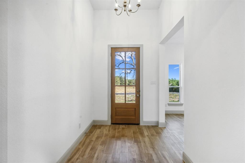 191 Lucky Ridge Lane Boyd, TX 76023 - Photo 7 of 38 an empty room with wooden floor and windows
