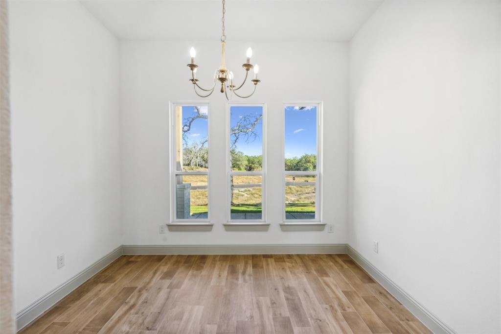 191 Lucky Ridge Lane Boyd, TX 76023 - Photo 8 of 38 a view of an empty room with wooden floor and a window